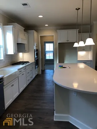 a kitchen with kitchen island a sink stainless steel appliances and cabinets