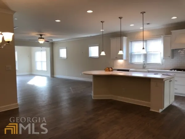 a kitchen with kitchen island a sink appliances and a counter top space