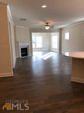 an empty room with windows fireplace and wooden floor