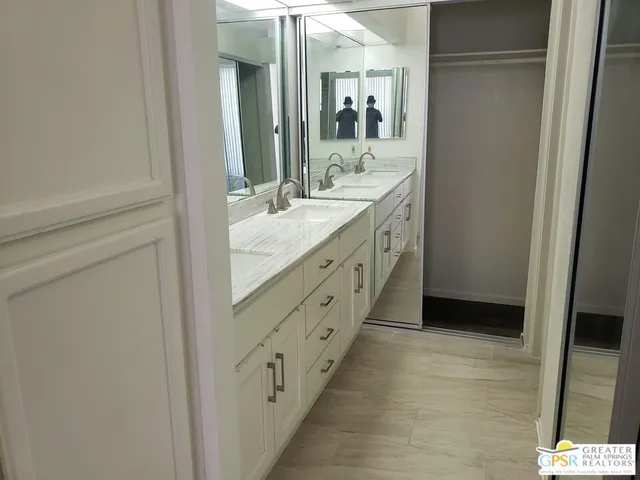 a spacious bathroom with a double vanity sink and a mirror