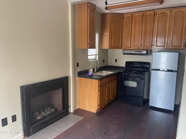 a kitchen with granite countertop wooden cabinets and a stove top oven