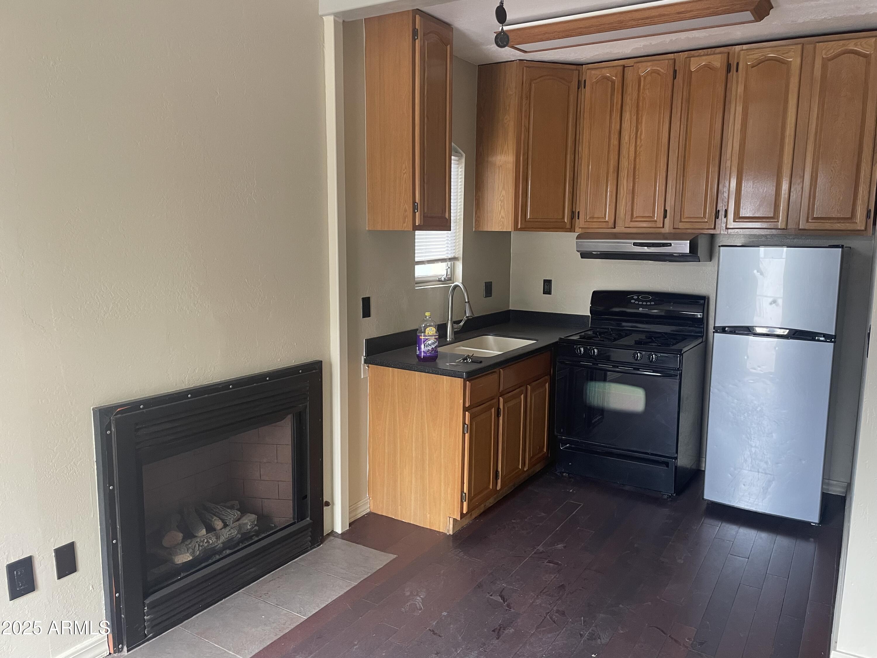 a kitchen with granite countertop wooden cabinets and a stove top oven
