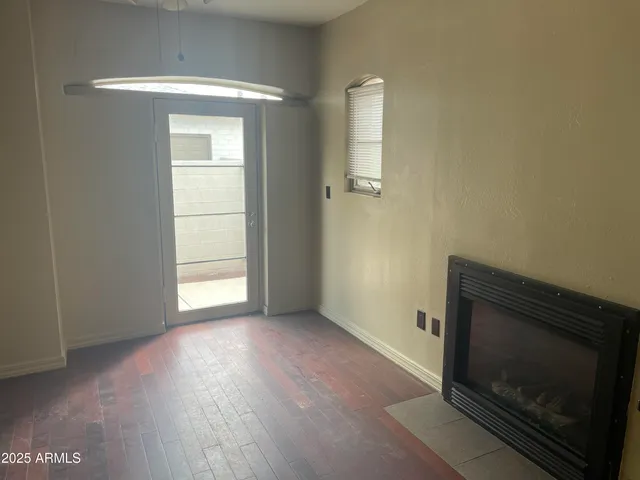 a view of an empty room with a fireplace and a window