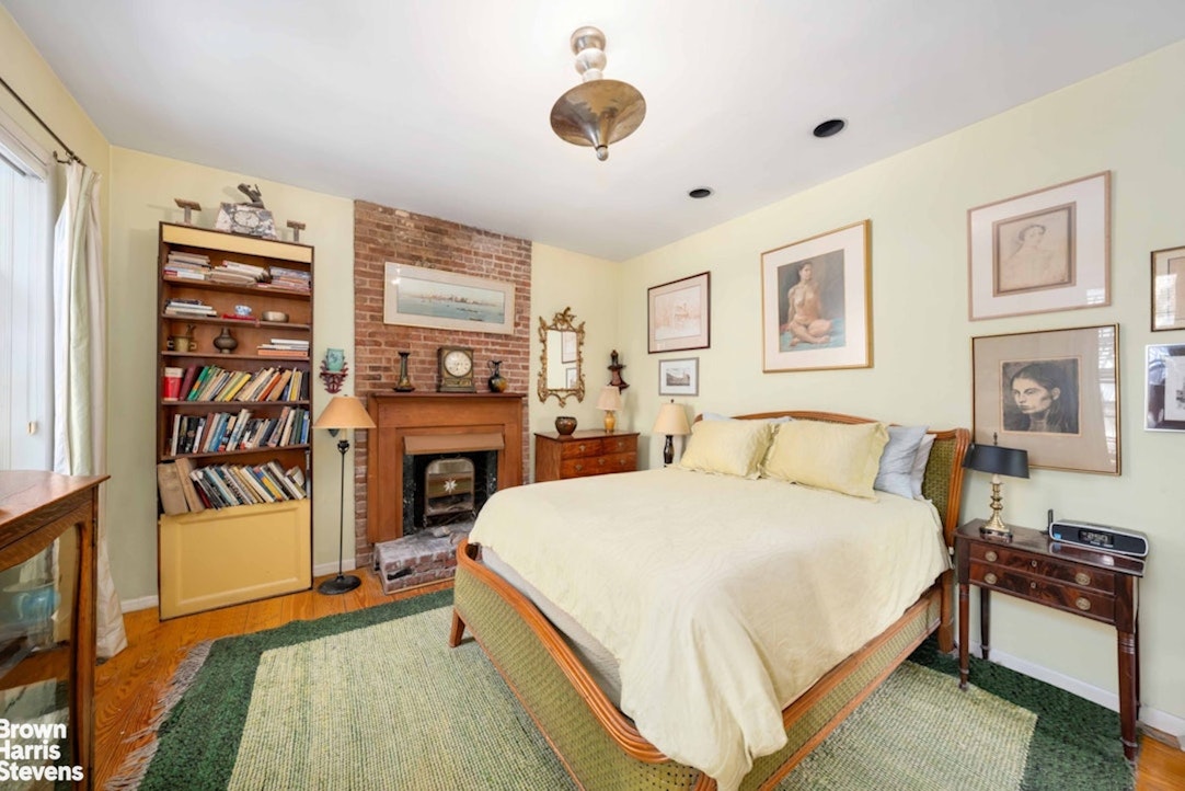 422 West 46th Street, Unit 2R Manhattan, NY 10036 - Photo 7 of 10 a bed room with a bed and a fireplace