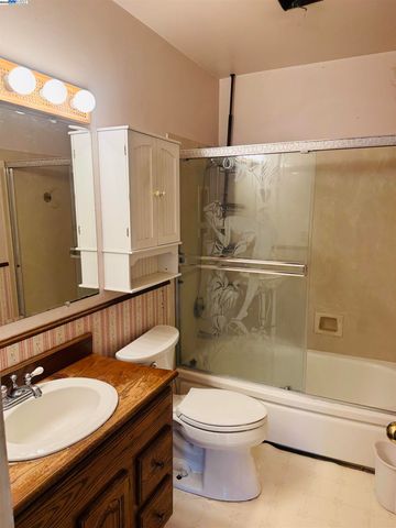 a bathroom with a granite countertop sink toilet a mirror and shower