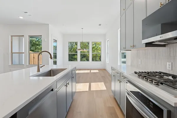 a kitchen with granite countertop a sink a stove and cabinets