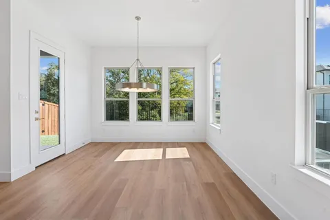 a view of empty room with wooden floor and fireplace