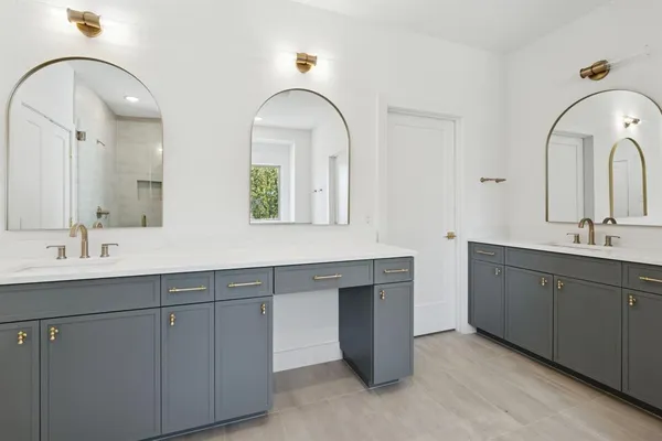 a bathroom with a double vanity sink mirror and shower