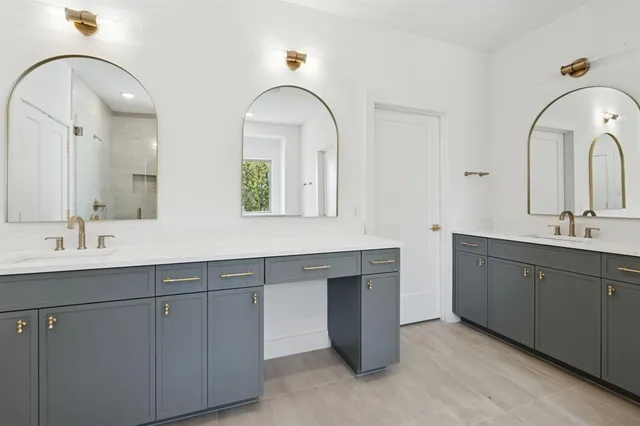 a bathroom with a double vanity sink mirror and shower