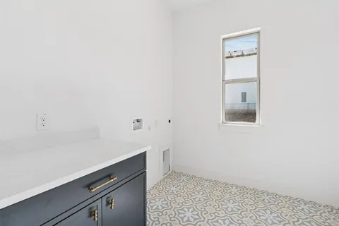 a room with a white wall and a stove