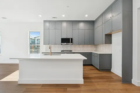 a view of a kitchen with a sink a fireplace and a window