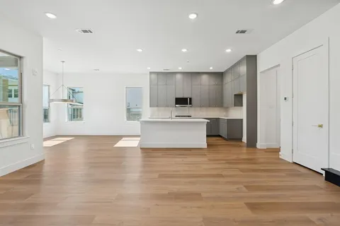a view of a kitchen with wooden floor and electronic appliances