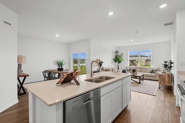 a kitchen with a sink a counter and chairs