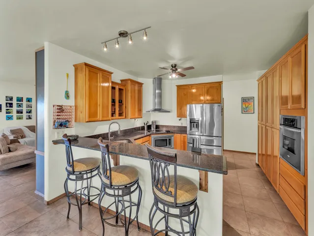 a room with stainless steel appliances kitchen island granite countertop furniture and a large window