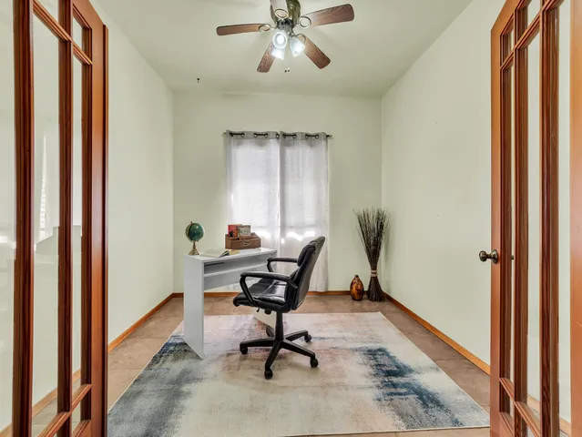 a view of a workspace with furniture and a window