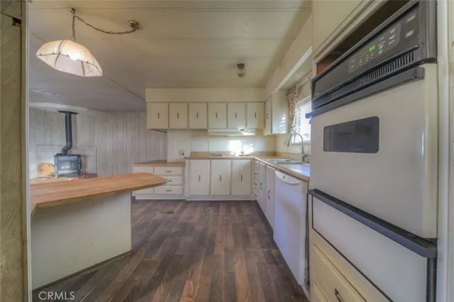 a kitchen with stainless steel appliances granite countertop a sink a stove and cabinets