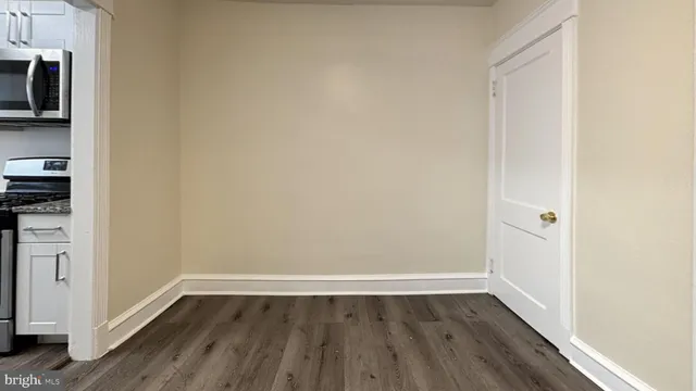 a view of a room with wooden floor and a window