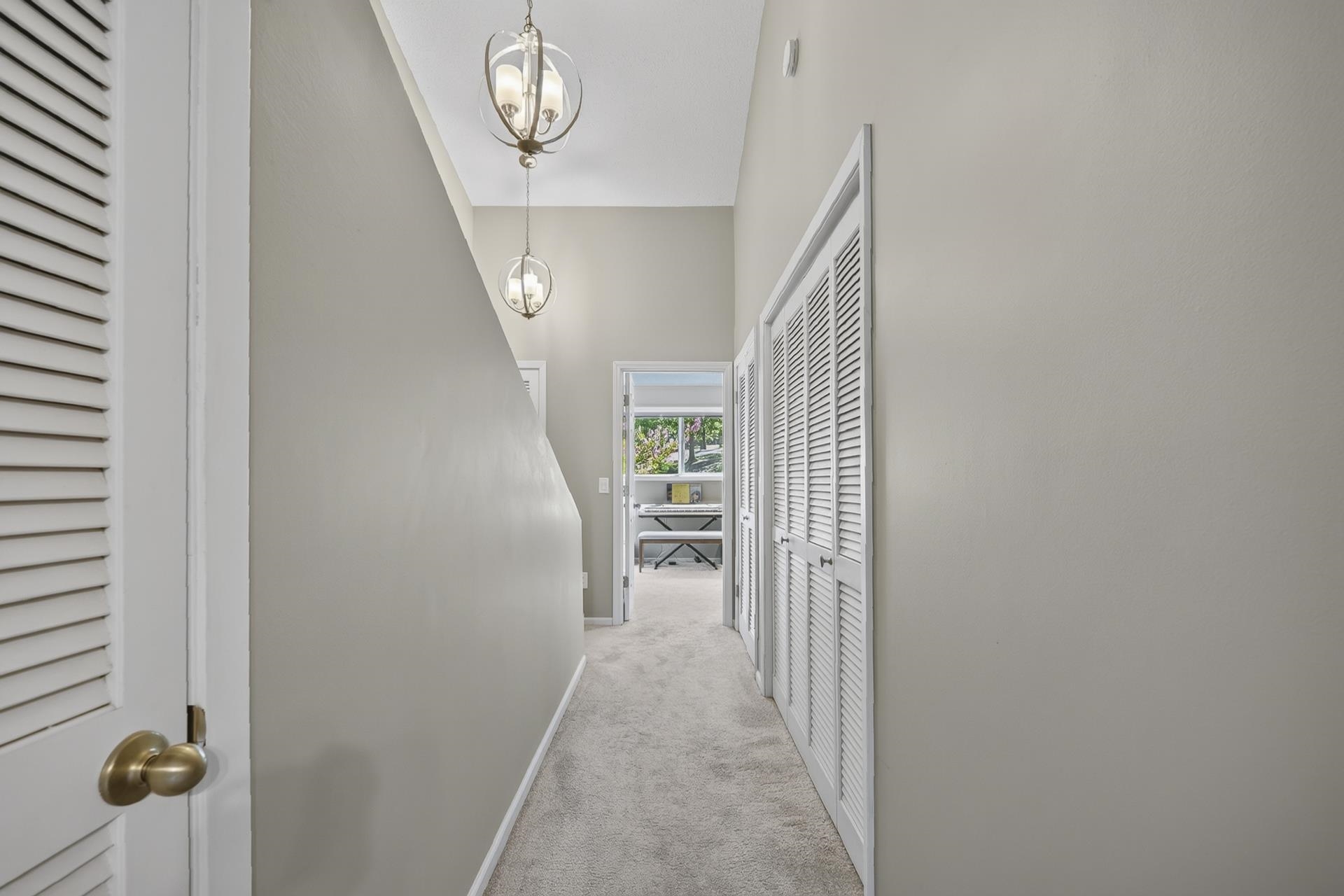 74 Driftwood Road Counce, TN 38326 - Photo 30 of 40 Hallway featuring vaulted ceilings and two spherical pendant light fixtures leading to Bedroom 2