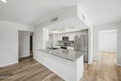 a kitchen with stainless steel appliances granite countertop a refrigerator and a sink