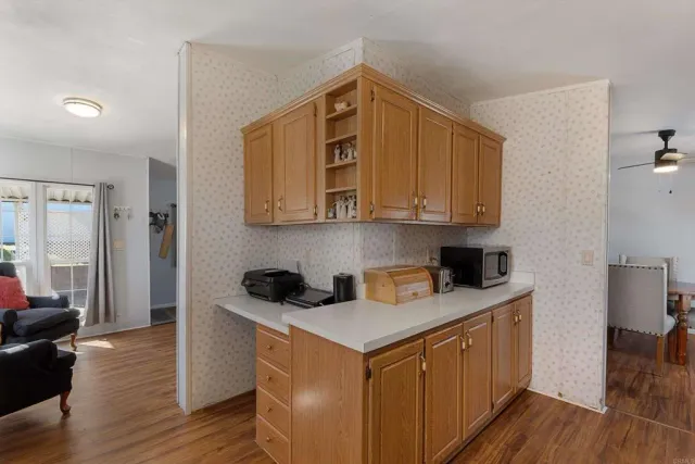 a kitchen with stainless steel appliances granite countertop a sink and cabinets with wooden floor