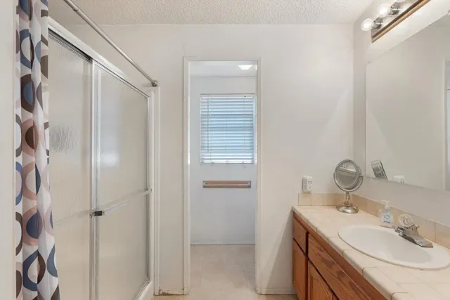 a bathroom with a sink a mirror and shower