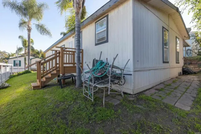 a view of a chair and table in backyard of the house