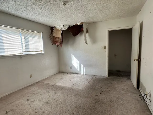 an empty room with windows and cabinet