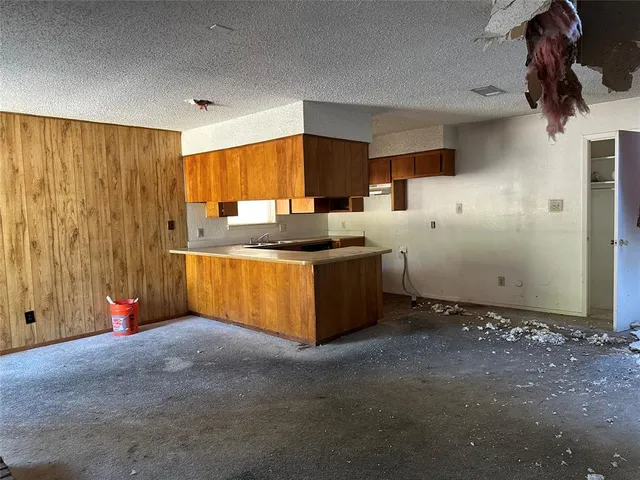 a kitchen with stainless steel appliances kitchen island granite countertop cabinets and window