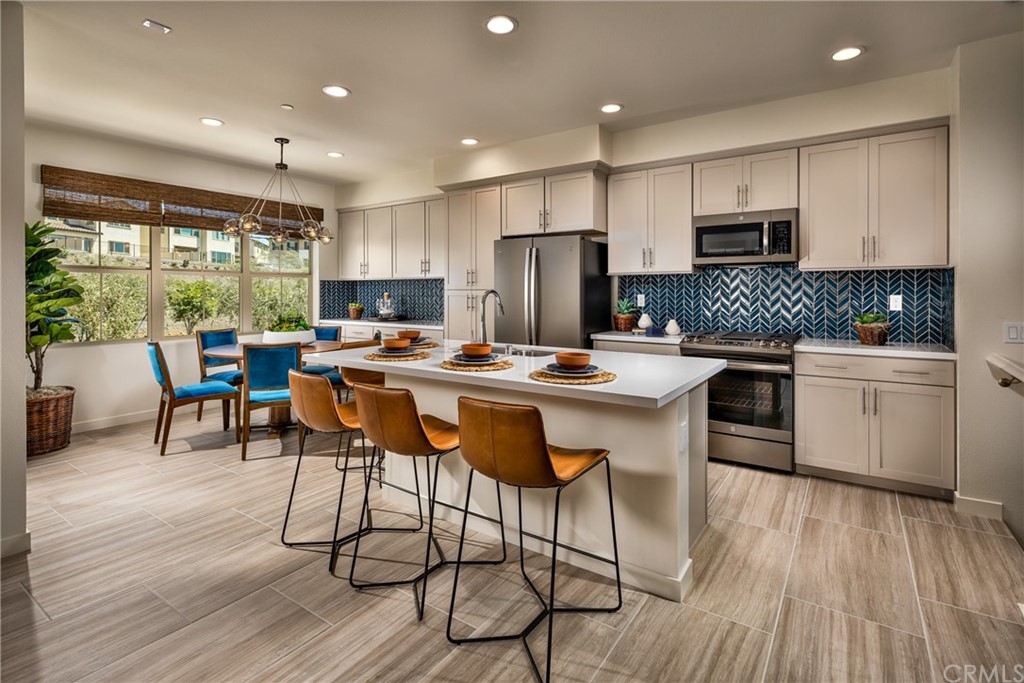 422 Coyote Pass Blanchard, ID 83804 - Photo 3 of 7 a kitchen with stainless steel appliances kitchen island granite countertop a table chairs and a wooden cabinets