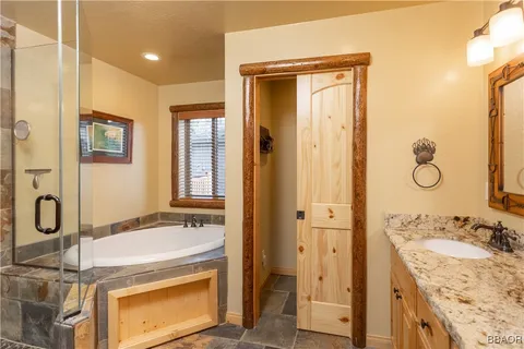 a bathroom with a granite countertop sink a mirror and a shower