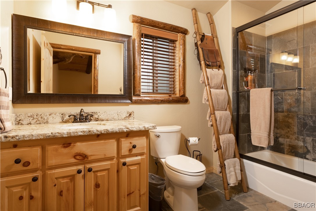 1389 Flintridge Avenue Big Bear City, CA 92314 - Photo 17 of 21 a bathroom with a granite countertop toilet sink and mirror