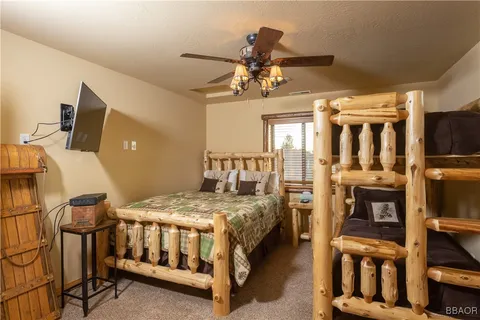 a bedroom with a bed a flat screen tv and chandelier