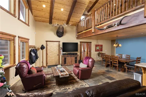 a living room with furniture kitchen view and a flat screen tv