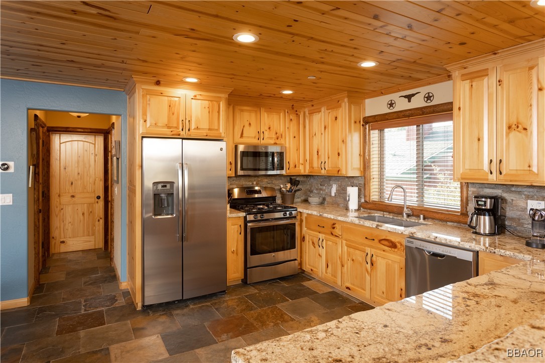 1389 Flintridge Avenue Big Bear City, CA 92314 - Photo 6 of 21 a kitchen with stainless steel appliances granite countertop a refrigerator a sink a stove and cabinets