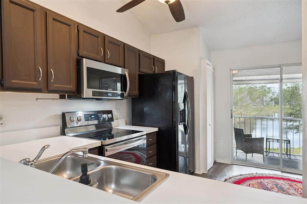 112 Reserve Circle, Unit 212 Oviedo, FL 32765 - Photo 8 of 54 a kitchen with stainless steel appliances wooden cabinets a sink and a refrigerator