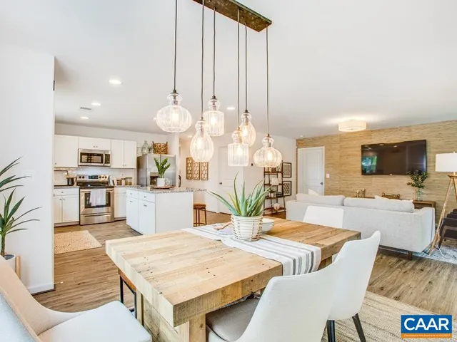 a living room with dining table furniture and a flat screen tv