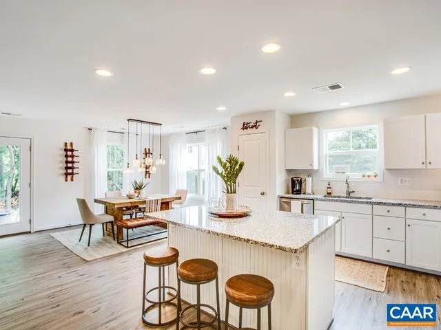 a kitchen with granite countertop white cabinets and stainless steel appliances