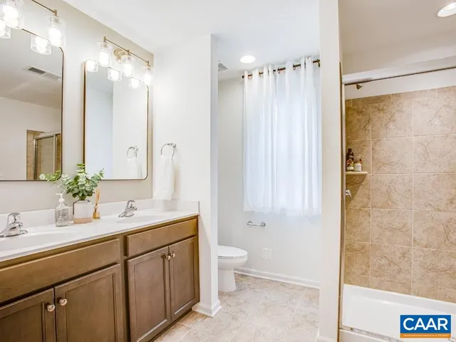 a bathroom with a double vanity sink mirror and shower