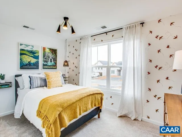 a bedroom with a bed and painting on the wall