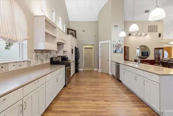 a large kitchen with kitchen island granite countertop a sink and cabinets