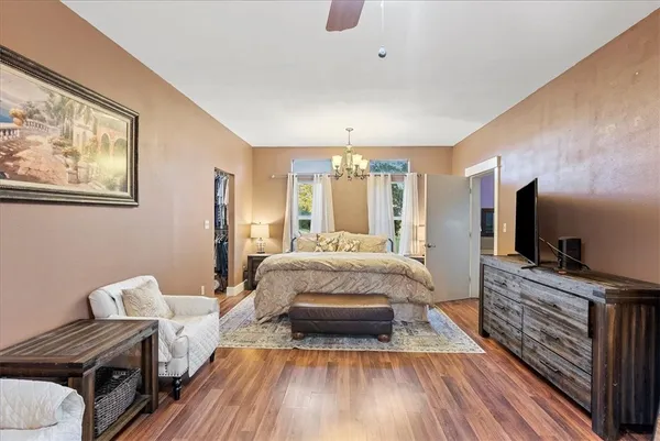 a spacious bedroom with a bed and flat screen tv