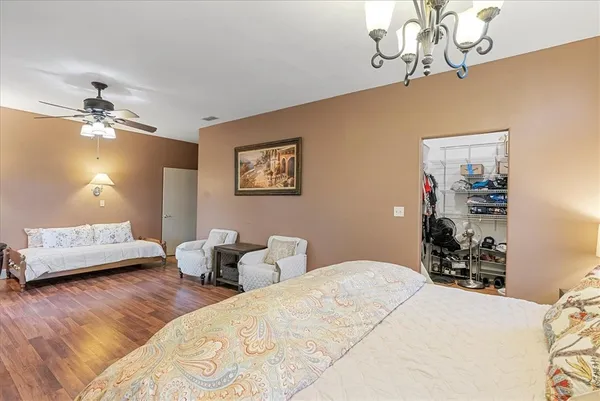 a bedroom with a bed chandelier and a window