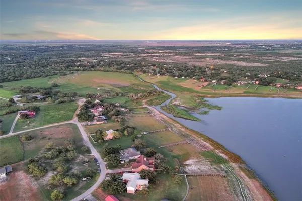 an aerial view of ocean and residential houses with outdoor space