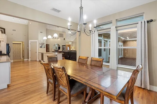 a dining room with furniture a chandelier and wooden floor