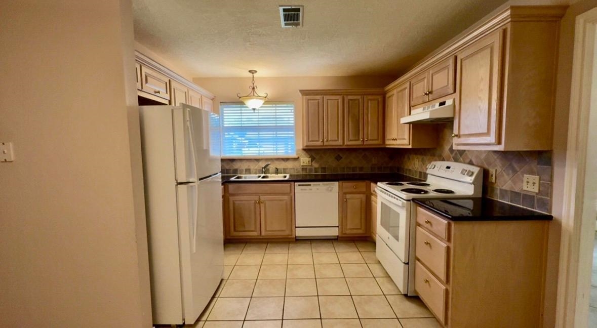 4665 Glen Oaks Circle Beaumont, TX 77708 - Photo 2 of 20 a kitchen with a refrigerator sink and cabinets