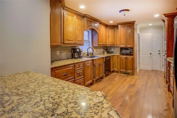 a kitchen with stainless steel appliances kitchen island granite countertop a refrigerator and a sink