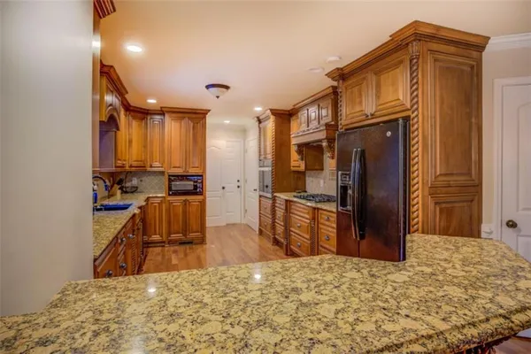 a kitchen with stainless steel appliances granite countertop a refrigerator and cabinets