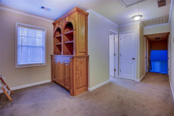 an empty room with a chandelier fan and windows