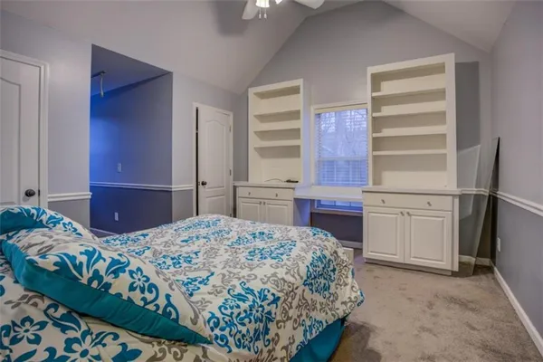 an empty room with wooden floor chandelier fan and windows