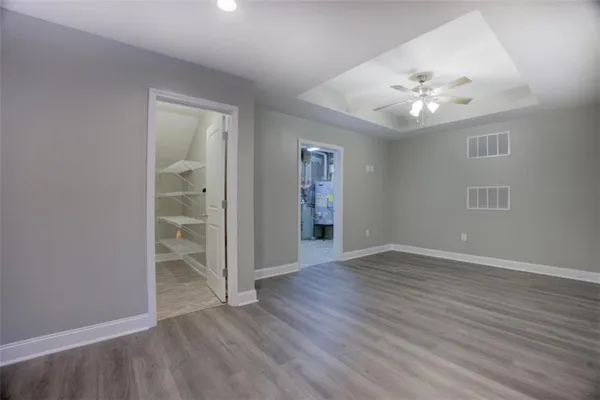 a view of an empty room and a chandelier fan